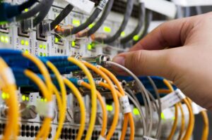 A man is connecting Fiber to one of the local fiber optic hubs